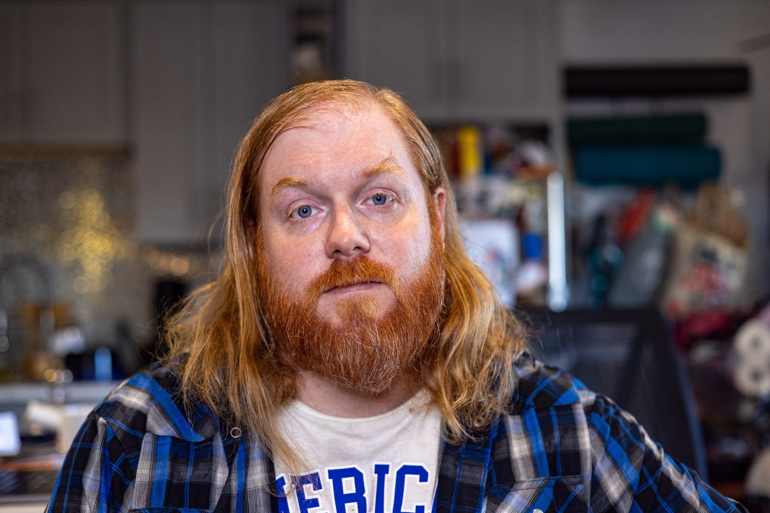 self portrait of a bearded red headed man with long hair and a blue shirt