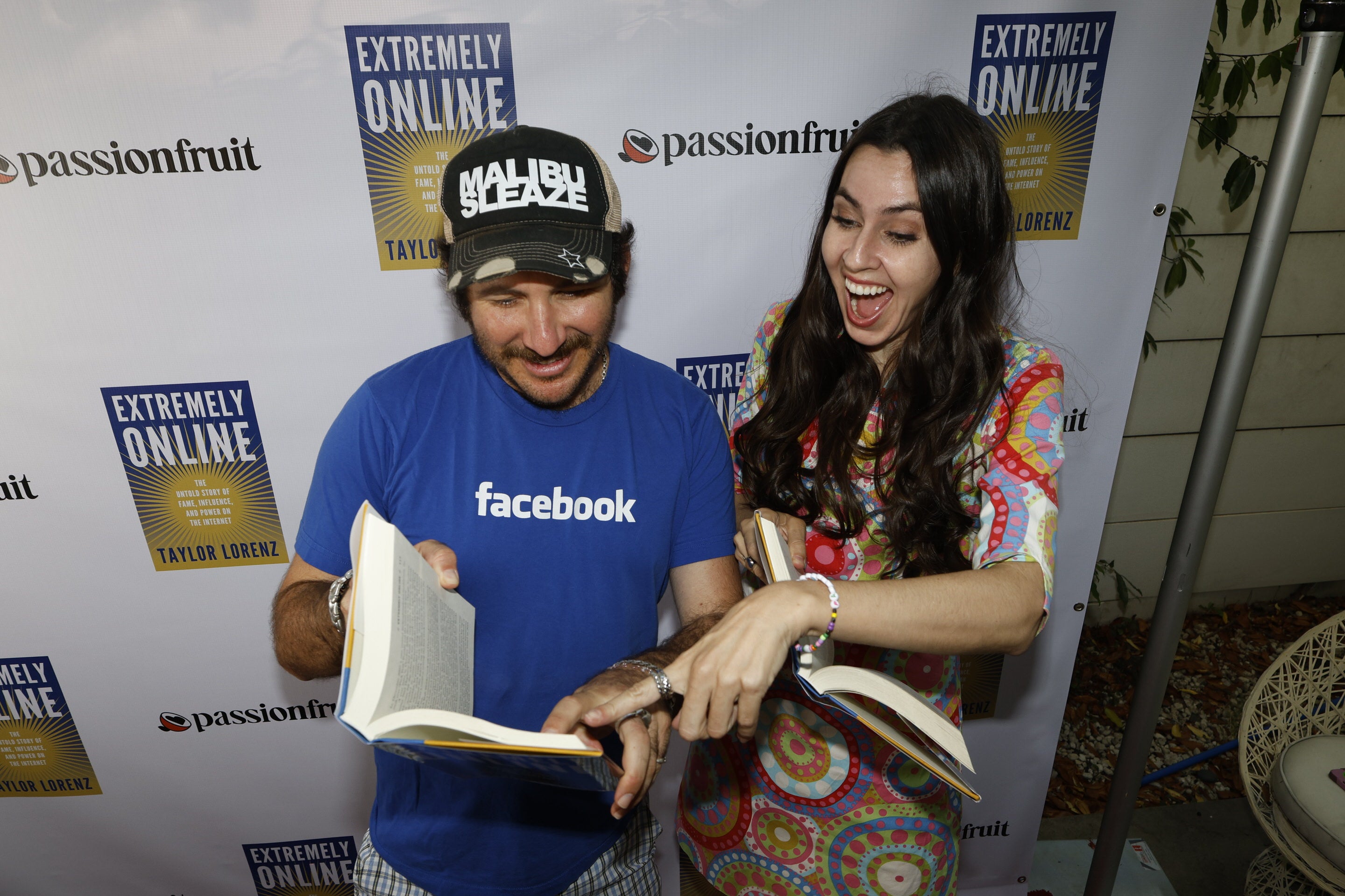 The Cobrasnake and Taylor Lorenz looking at a hardcover copy of Extremely Online