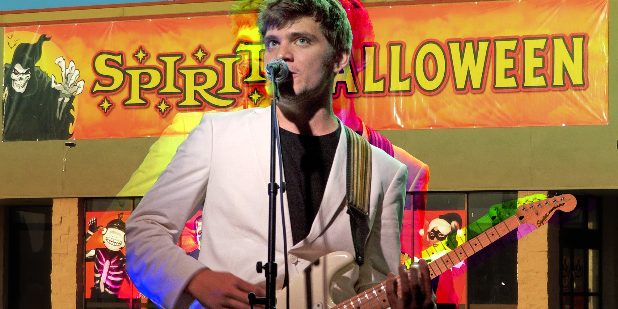 Nick Lutsko playing guitar in front of Spirit Halloween Store