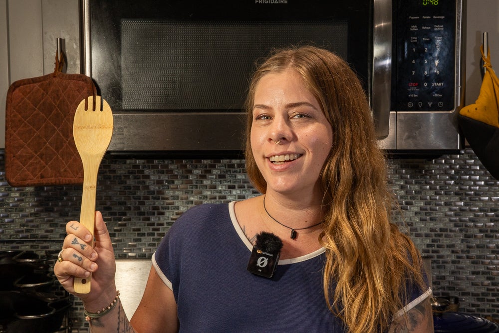 Rode Wireless ME mic, a photo of tattoo artist Emily Effler demonstrating the size of the mic with the wind screen