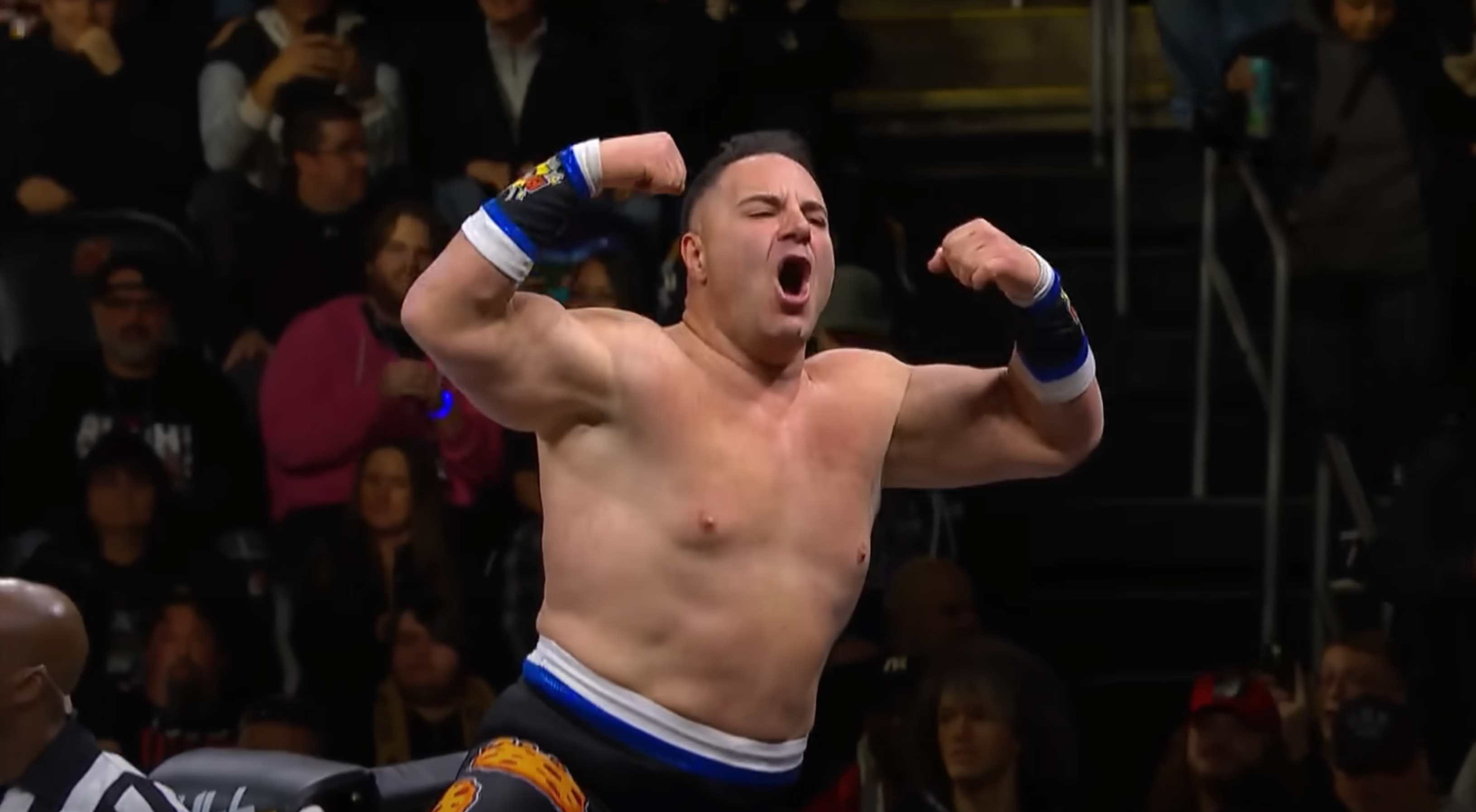 AJ flexing his muscles during a wrestling match