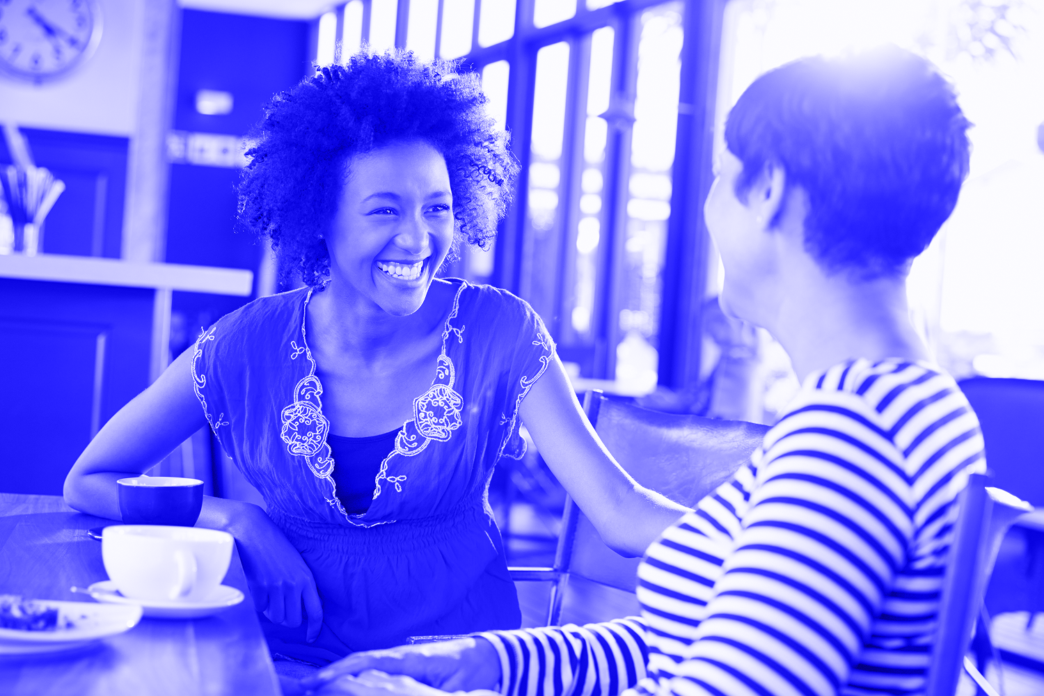 two middle aged women smiling and talking