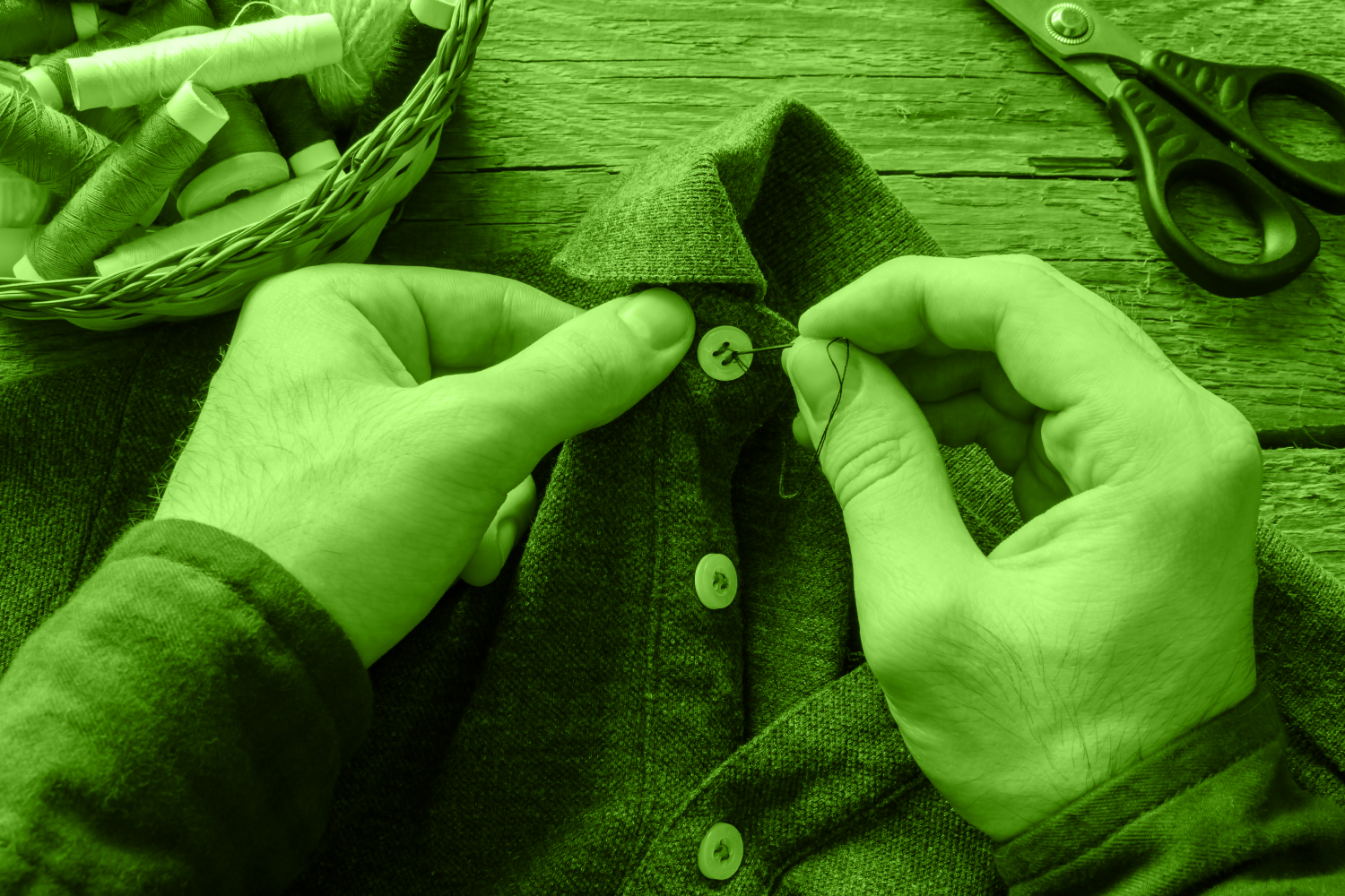 man's hands sewing a button on a shirt