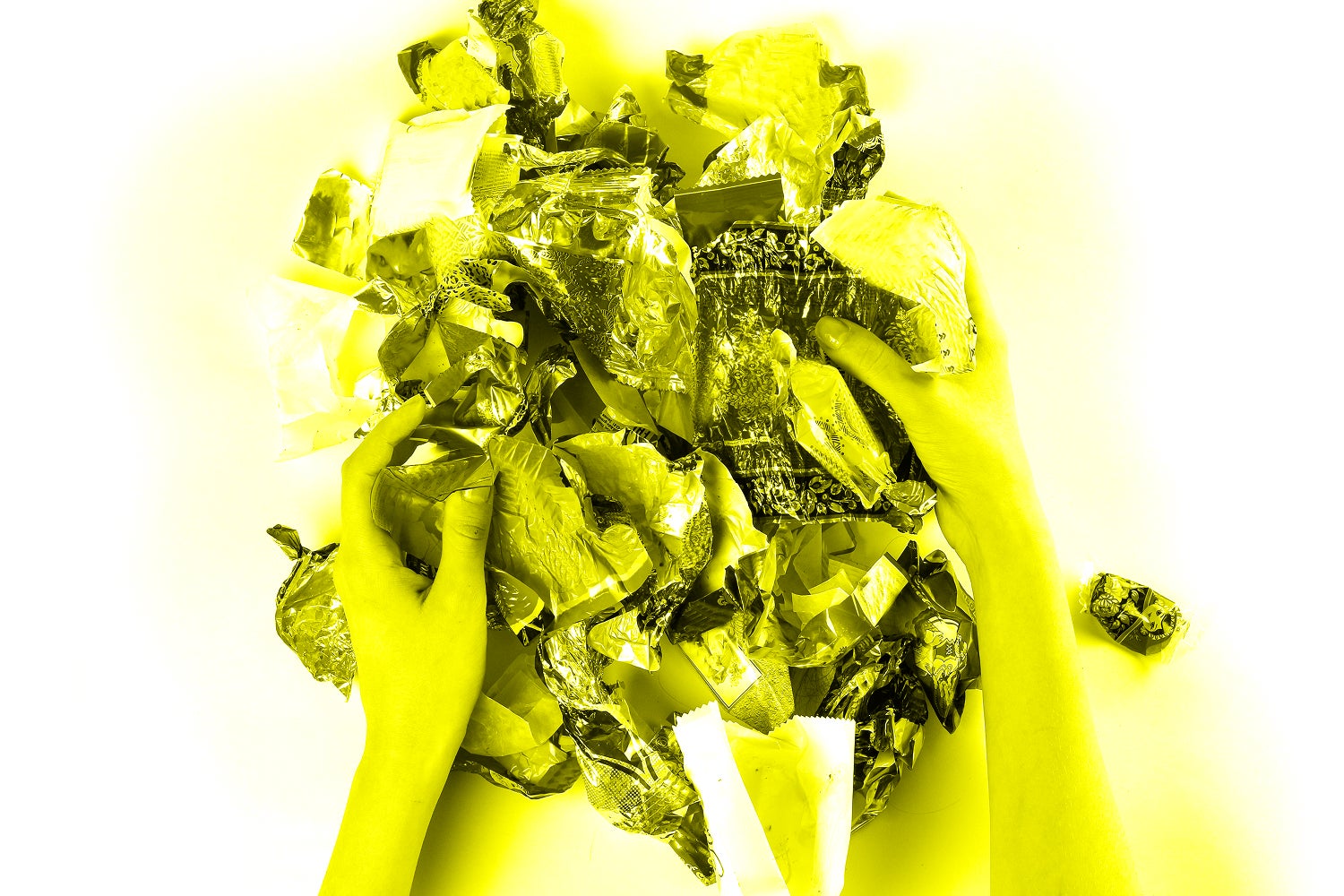 Hands holding a bunch of candy wrappers
