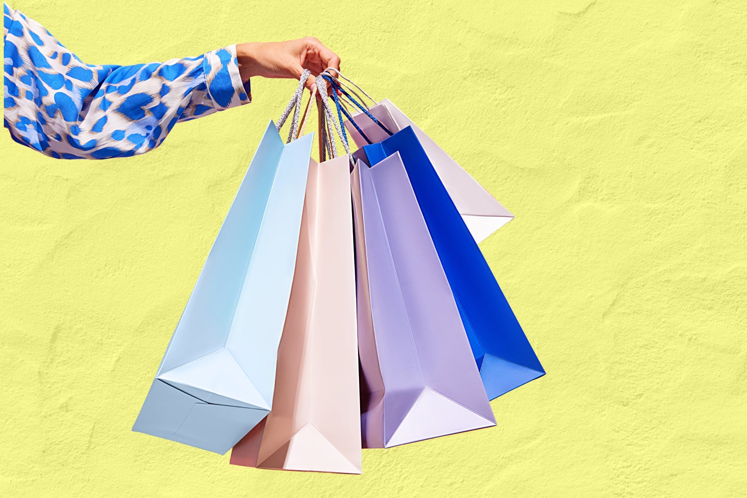 Closeup of woman hand holding purchase blue bags